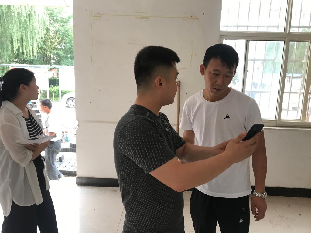 街办工作人员与设计公司现场对便民服务厅进行设计并协商装修方案。